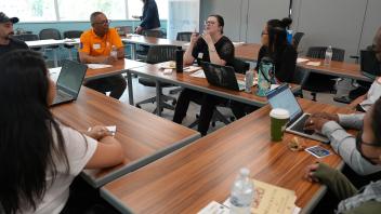 High school teacher expressing her idea at the roundtable discussion