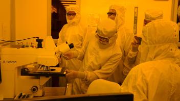 Participants observing the processed silicon wafer under microscope